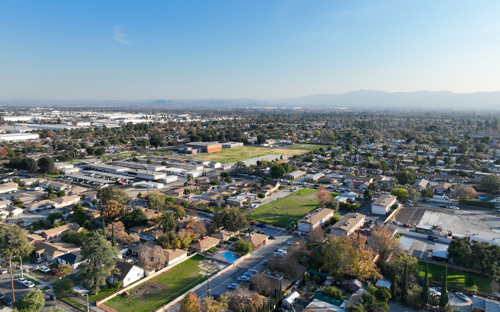 Aerial view of a residential neighborhood in San Bernardino County, California, with mountains in the distance
